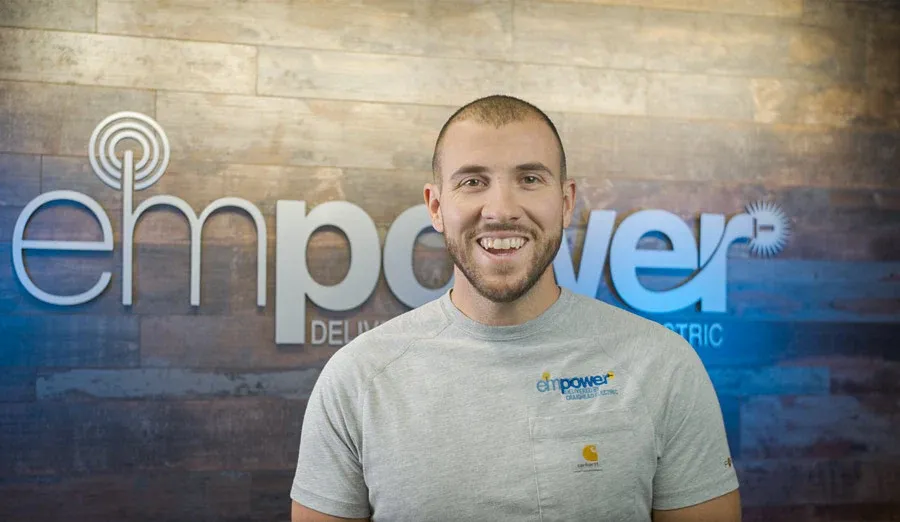 A member of the Empower team presenting to camera in front of the brand wall